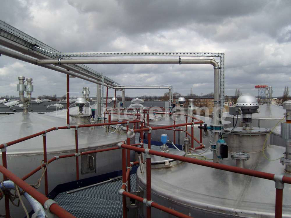 Chemical plant walkway equipped with a safety guardrail made from Interclamp tube clamp fittings, demonstrating effective safety protocols.